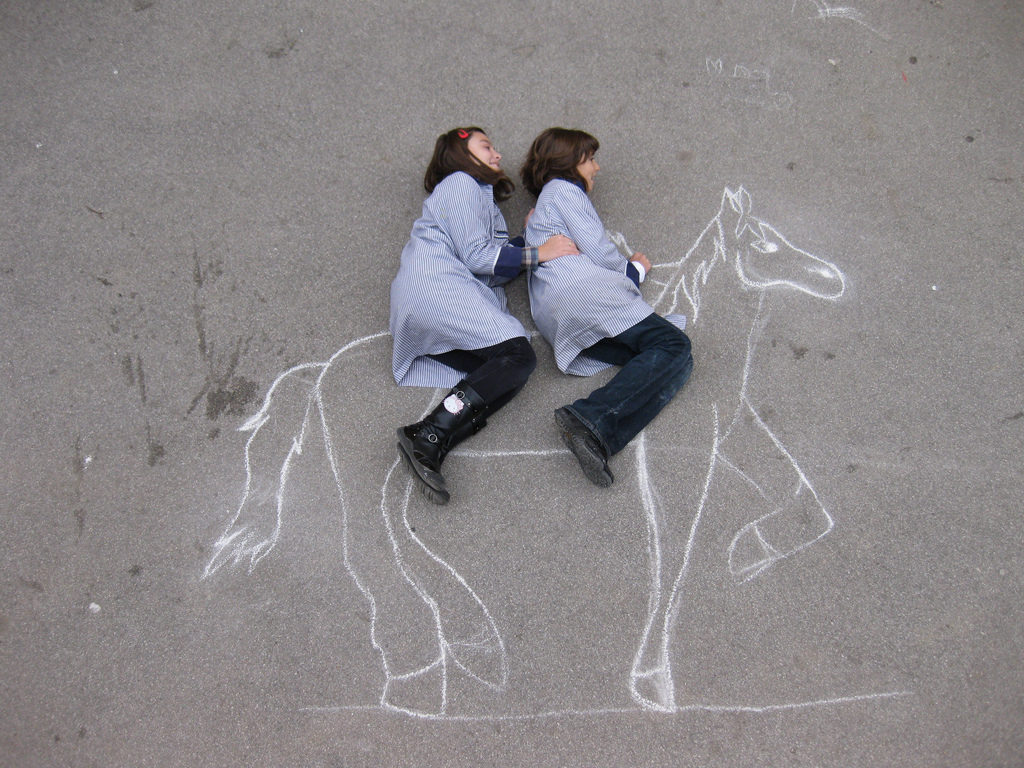 Alumnos de quinto creando dibujo con tiza en el patio para aplicar conceptos de la perspectiva.